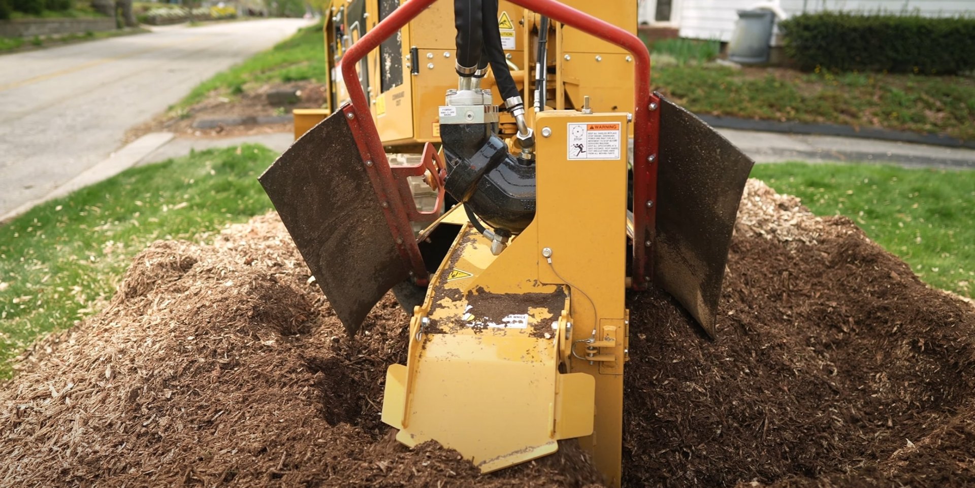 Professional stump grinding equipment removing tree stump with wood chips